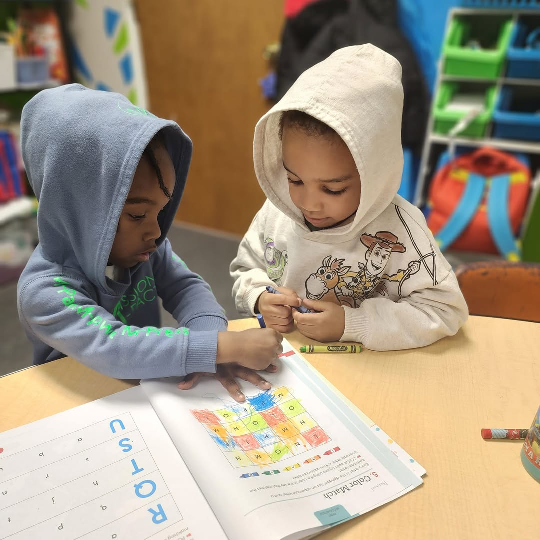 Two children working in a workbook
